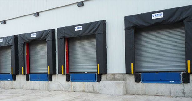 Cold Storage warehouse roll up doors showing four without any trucks lined up.